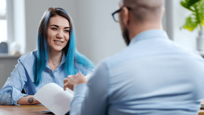 Job candidate with blue dyed hair being interviewed for a new job