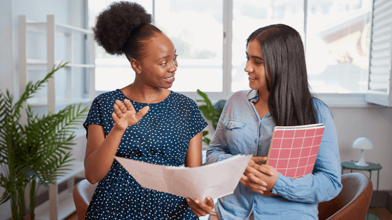 Two women at work having a positive conversation