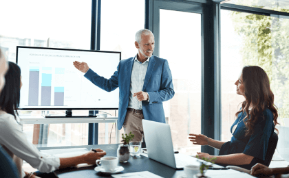 Man giving a presentation to colleagues showing positive business trends 