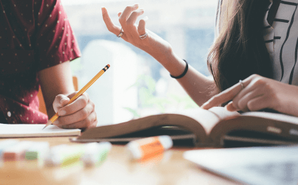 Two people sit next to each other and talk, showing how to improve emotional intelligence through strong communication skills 