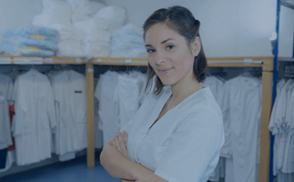 Woman smiling in front of clean linens
